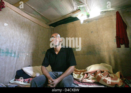 25-j hrige El Mostafa aus Marokko sitzt auf seinem Bett in seiner Hütte aus Paletten aus Holz, Pappe und Kunststoff Verkleidungen in El Ejido, Spanien, 9. Oktober 2007. El Mostafa ist einer der vielen Tagelöhner, die außerhalb der Stadt in eine so genannte "Chabola", fehlende sanitäre Einrichtungen, fließendes Wasser und rechtliche Strom lebt und arbeitet in den regionalen Gewächshäusern. Foto: Bodo Marks Stockfoto