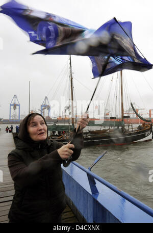 Eine Frau kämpft mit ihrem Schirm bei starken Winden in Hamburg, Deutschland, 1. März 2008. Orkan "Emma" streiften über Deutschland, aber die Schäden sind nicht so schädlich ist wie erwartet. Foto: Maurizio Gambarini Stockfoto