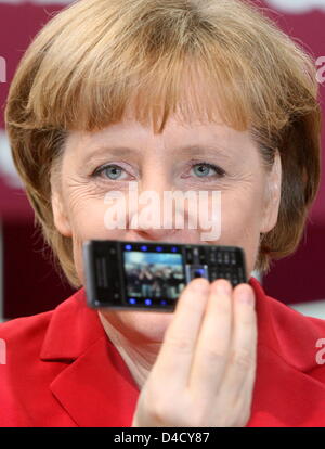 Bundeskanzlerin Angela Merkel Posen mit einem SonyEricsson Handy bei der IT Handel Messe CeBIT in Hannover, 4. März 2008. Ab 04 bis 09 März rund 5.500 Aussteller aus 75 Ländern präsentieren Messe ihre neuesten Produkte auf der weltweit größten auf digitalen IT-und Telekommunikationslösungen. Foto: KAY NIETFELD Stockfoto