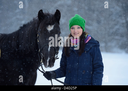 Junge Frau mit Arabo-Haflinger-Pferd in Schnee, Oberpfalz, Deutschland, Europa Stockfoto