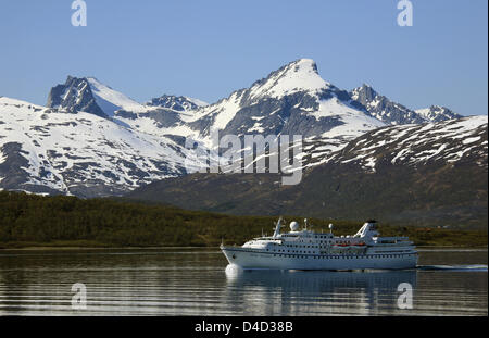 (Dpa-Datei) - Kreuzfahrtschiff "Ocean Majesty" in ruhigen Gewässern vor Schnee bedeckt 'Store Blamannen' Berg, Nord-Norwegen, 5. Juli 2007. Foto: Hinrich Baesemann Stockfoto