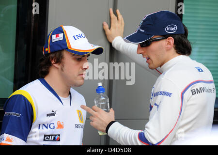 Spanische Formel1-Fahrer Fernando Alonso (L) von Renault und polnische Formel-1-Pilot Robert Kubica BMW Sauber haben ein Wort im Fahrerlager vor dem Start der Formel 1 Australian Grand Prix im Albert Park Circuit in Melbourne, Australien, 16. März 2008. Foto: GERO BRELOER +++(c) Dpa - Bildfunk +++ Stockfoto