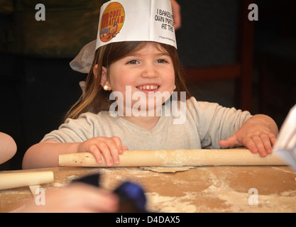 5 Jahre alten religiösen jüdischen Mädchen lernt Passah durch Backen Matza beim Modell Matza Bäcker in Brooklyn, New York Stockfoto