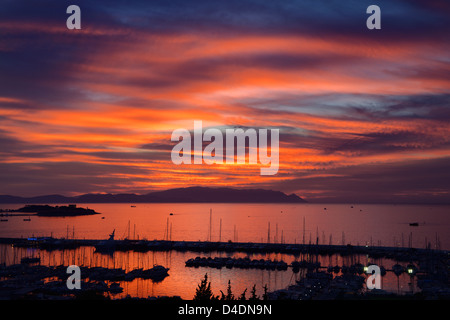 Feurigen Sonnenuntergang bei Kusadasi Türkei Hafen mit guvercin adasi Insel in der Ägäis mit Bergen von Samos, Griechenland Stockfoto