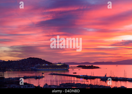 Roter Himmel Sonnenuntergang bei Kusadasi Türkei Hafen mit guvercin adasi Schloss und Kreuzfahrtschiff auf das Ägäische Meer mit der Insel Samos Stockfoto