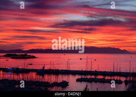 Roter Himmel Sonnenuntergang am Hafen von Kusadasi Türkei mit Guvercin Adasi Insel Burg auf das Ägäische Meer mit Bergen von Samos Griechenland Stockfoto