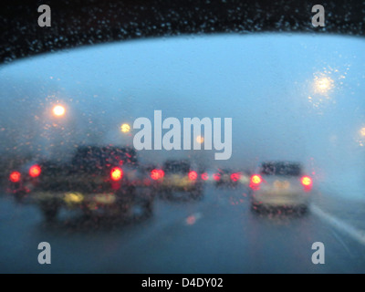 Verkehr an einem regnerischen nassen Highway in der Abenddämmerung Stockfoto