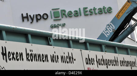 Das Logo der unruhigen Hypothekenbank Hypo Real Estate (HRE) abgebildet ist, neben einem Schild mit der Aufschrift "Wir Magie aber entsorgen professionell am Stammsitz in München, 6. Oktober 2008 nicht leisten können". Die deutsche Regierung und Finanzen Industrie verhindert die Bankenpleite zum zweiten Mal in der letzten Minute mit einer erweiterten Bail-Out, 05. Oktober beschlossen. Wer Verhandlungen Stockfoto