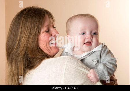 Eine ältere Mutter hält ihr Baby junge von sechs Monaten Stockfoto