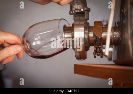 Winzer gießt einen Geschmack von Wein vom Fass ins Glas. Stockfoto