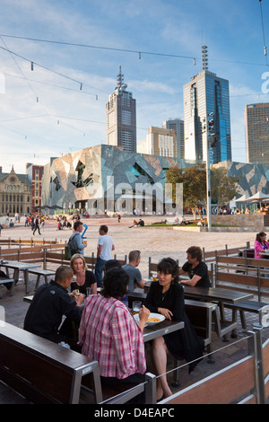 Menschen entspannen in bar am Federation Square mit Skyline der Stadt im Hintergrund. Melbourne, Victoria, Australien Stockfoto