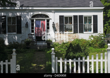 Ein altes Haus mit einer amerikanischen Flagge an der Tür, in Thomaston, Maine Stockfoto