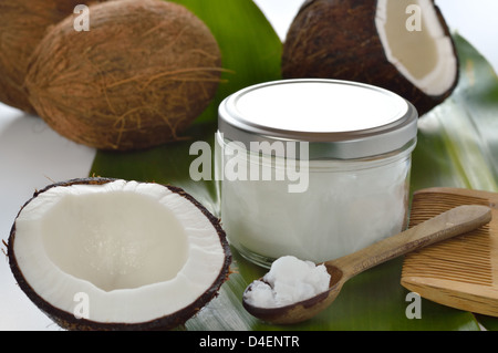 Kokosnüsse und Bio-Kokosöl in einem Glas auf weißem Hintergrund. Haarbehandlung. Stockfoto