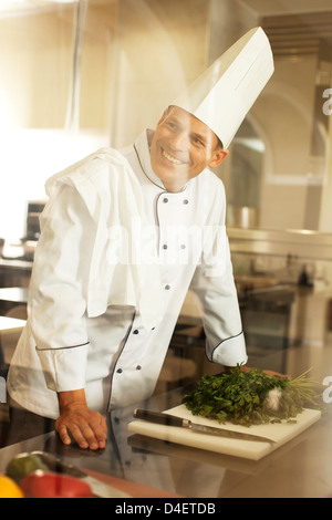 Koch lächelnd in Restaurantküche Stockfoto