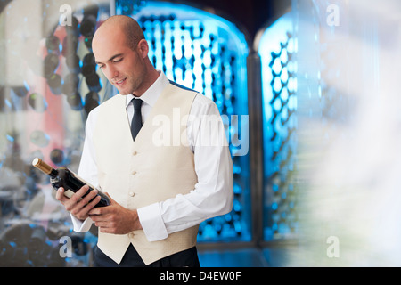 Kellner lesen Flasche Wein in Küche Stockfoto