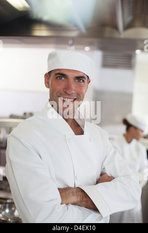 Koch lächelnd in Restaurantküche Stockfoto