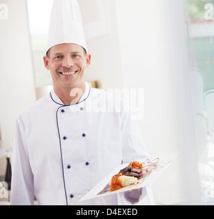 Teller mit Essen im Restaurant mit Küchenchef Stockfoto