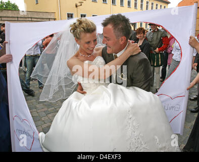 Deutsche dreimaligen Olympischen Biathlon Champion Sven Fischer (R) und seine Frau Doreen (L) verlassen die Kirche, nachdem ihre kirchliche Trauung in Schmalkalden, Deutschland, 24. Mai 2008. Das Paar haben bereits vor einem Jahr standesamtlich geheiratet. Foto: MARTIN SCHUTT Stockfoto
