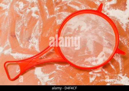 Ein Sieb auf einer bemehlten Arbeitsfläche. Stockfoto