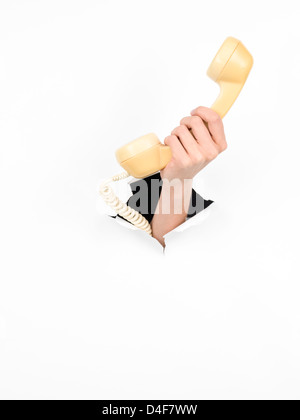 Nahaufnahme von weiblicher Hand, die ein Telefon mit einem zerrissenen Weißbuch, isoliert Stockfoto