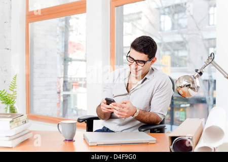 Geschäftsmann mit Handy im Büro Stockfoto