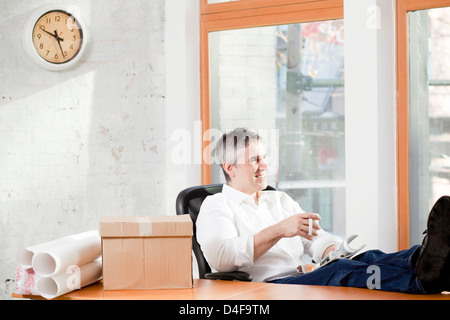 Entspannung am Schreibtisch im Büro Geschäftsmann Stockfoto