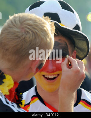 Zwei deutsche Fans malen ihre Gesichter vor der UEFA EURO 2008 Halbfinale Deutschland gegen die Türkei auf die Fanmeile am Brandenburger Tor in Berlin, Deutschland, 25. Juni 2008 ausgestrahlt. Eine halbe Million deutsche und türkische Fans wurden erwartet, sehen Sie das Spiel und die Partei vereint. Foto: Gero Breloer Stockfoto