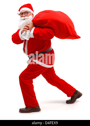 Senior woman Weihnachtsmann Uniform tragen, gehen mit voller Beutel Stockfoto