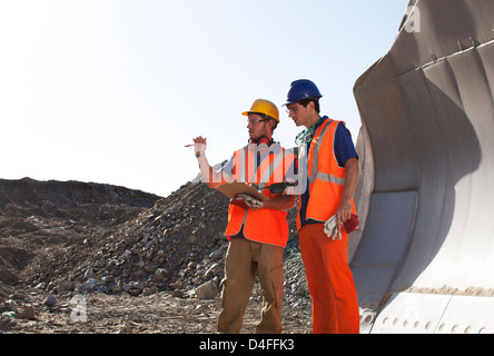 Arbeitnehmer, die reden von Maschinen im Steinbruch Stockfoto