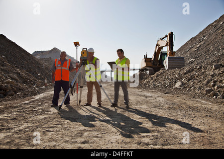 Arbeitnehmer mit Nivellierung Maschinen im Steinbruch Stockfoto