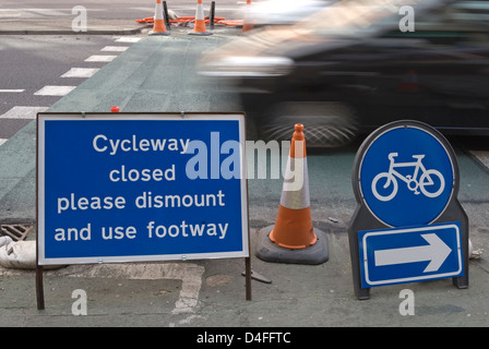 Cycleway geschlossen bitte demontieren und Fußweg Zeichen mit vorbeifahrenden Bewegungsunschärfe Auto, Kingston nach Themse, Surrey, england Stockfoto