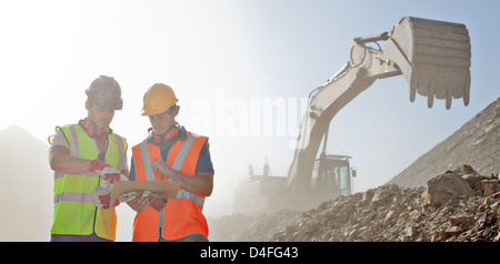 Arbeitnehmer, die Baupläne im Steinbruch zu lesen Stockfoto