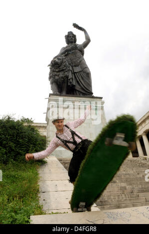 Hedonist Jan Kisselmann reitet seine 2m "Longboard" Skateboard fallenden Kunstrasen vor der Statue der "Bavaria" auf "Theresienwiese" in München, Deutschland, 5. August 2008. Kisselmann baut diese Arten von XXXL Skateboards, da 10 zehn Jahre und will seine "grüne" Board fahren während der diesjährigen Trachten auf dem "Oktoberfest Parade". Foto: FELIX HOERHAGER Stockfoto