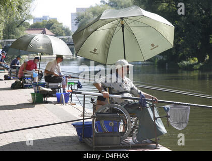 Angler-Praxis unter großen Sonnenschirmen am Rande des Flusses "Havel" in Potsdam, Deutschland, 7. August 2008. Teilnehmer aus acht Nationen nehmen Teil an den zehnten Fishing World Championships für behinderte die in Potsdam, Deutschland am 9. August 2008 beginnen werden. Gefangenen Fisch wird auf anderen Gewässern übertragen werden. Deutschland Gastgeber der Weltmeisterschaft zum ersten Mal. Foto: BERN Stockfoto