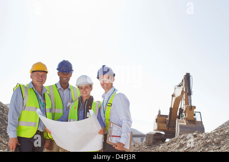 Business-Leute lesen Baupläne im Steinbruch Stockfoto