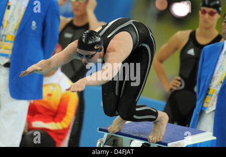 Deutsche Schwimmerin Britta Steffen betritt den Pool während Teamkollege sieht Antje Busschulte (R) im Finale der 4 x 100 M Frauen-Freistilstaffel während der Beijing Olympischen Spiele 2008 in Peking 10. August 2008 auf. Foto: Bernd Thissen Dpa (c) Dpa - Bildfunk Stockfoto