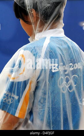 Ein Volenteer trägt einen Regenmantel, Stand in der Nähe des Gerichts in das Olympic Green Tenniszentrum an der Beijing Olympischen Spiele 2008 in Peking, China 10. August 2008. 1. Runde Männer ist einziges Spiel mit deutschen Nicolas Kiefer (GER) und Max Mirnyi (BLR) unhold Ursache von heavy Rain. Foto: Karl-Josef Hildenbrand Dpa (c) Dpa - Bildfunk Stockfoto