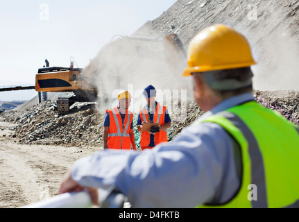 Geschäftsmann beobachten Arbeiter im Steinbruch Stockfoto