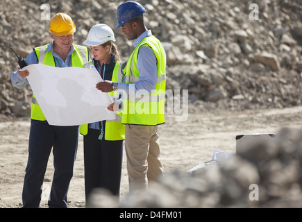 Business-Leute lesen Baupläne im Steinbruch Stockfoto