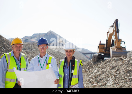 Business-Leute lesen Baupläne im Steinbruch Stockfoto