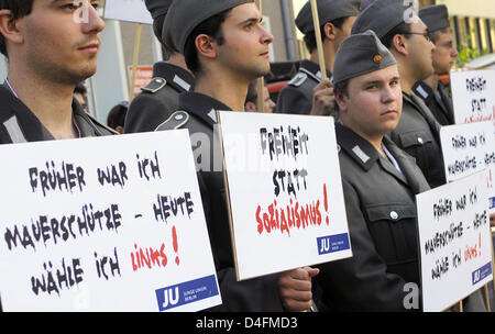 Mitglieder von der jungen christlichen Demokraten (JU) gekleidet in Uniformen der nationalen Volksarmee Armee (NVA) und tragen Schilder mit der Aufschrift "Freiheit statt Sozialismus" und "Ich war ein DDR Grenzschutz - jetzt ich links Stimmen" Stand vor der Parteizentrale von "Die linke" in Berlin, 13. August 2008. Die Kampagne fand anlässlich des 47. Jahrestages des Baus des t Stockfoto