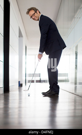 Geschäftsmann Golfball ins Büro Stockfoto