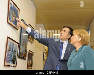 Der georgische Präsident Michail Saakashvili zeigt Bilder an die deutsche Bundeskanzlerin Angela Merkel in Tiflis, Georgien, 17. August 2008. Merkel unternommen auf einer ihrer heikelsten diplomatischen Herausforderungen bisher, durch die Injektion selbst ins Zentrum der Gespräche über die militärische Showdown zwischen Russland und Georgien zu lösen. Foto: Sandra Steins Stockfoto