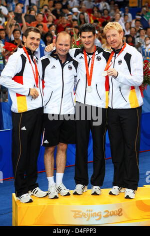 Deutschlands Trainer Richard Prause (2 L) feiert mit diesem Spieler (L-R) Timo Boll, Dimitrij Ovtcharov und Christian Suess nach Receiging ihr Silber während der Siegerehrung in der Men'sTable Tennis Team Goldmedaille-Veranstaltung während der Olympischen Spiele 2008 an der Peking University Gymnasium Beijing, China, 18. August 2008 Medaillen. Foto: Jens Buettner Dpa ## #dpa### Stockfoto