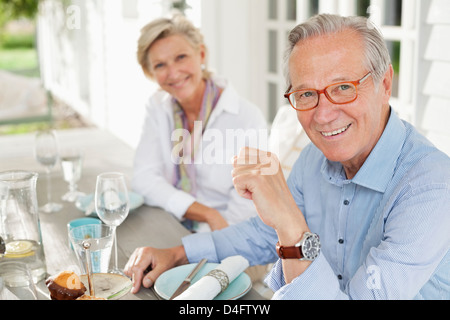 Paar lächelnd am Tisch zusammen Stockfoto