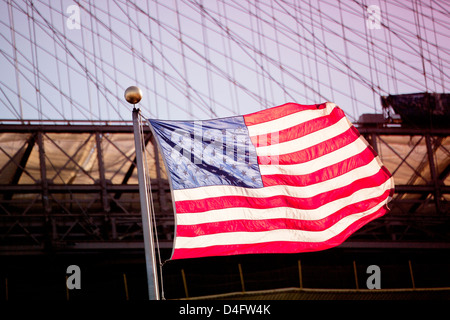 Amerikanische Flagge winken durch städtische Brücke Stockfoto