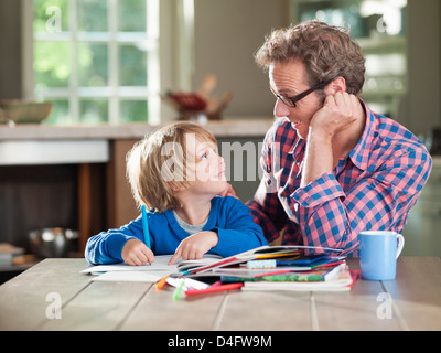 Vater und Sohn, die Hausaufgaben am Küchentisch Stockfoto