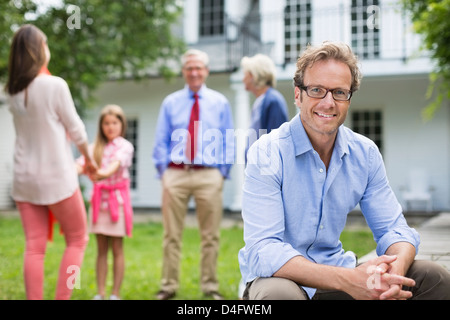 Mann lächelnd außen Haus Stockfoto