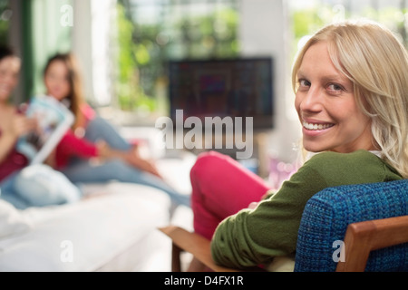 Lächelnde Frau im Sessel sitzen Stockfoto
