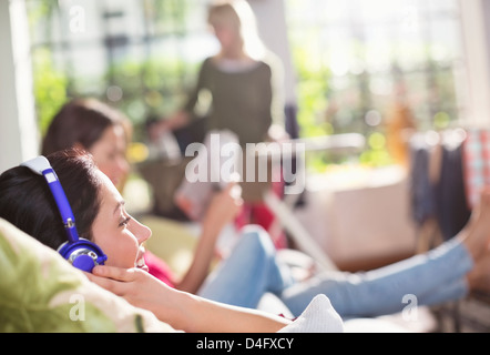 Frau, zuhören, Kopfhörer auf sofa Stockfoto